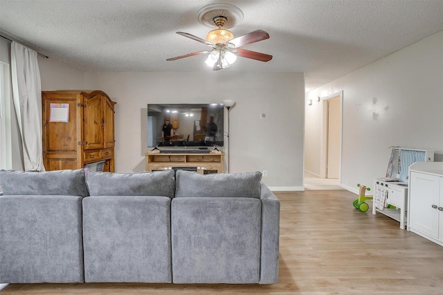 423 Parkview Dr, Burleson, TX 76028 - living area featuring a ceiling fan, a textured ceiling, light wood-type flooring, and baseboards