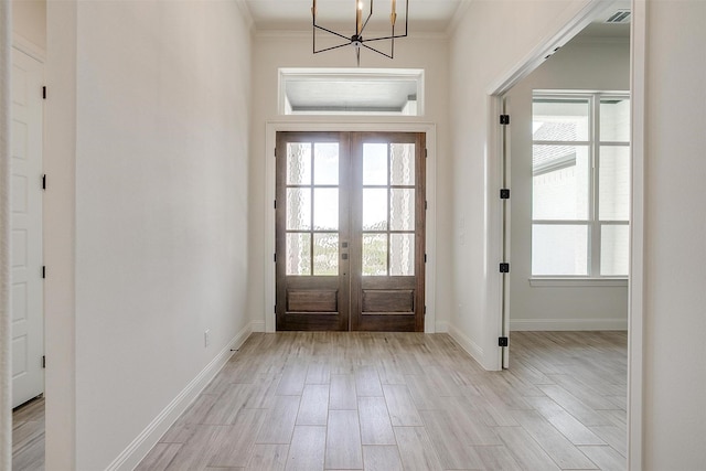823 Wind River Pass, Azle, TX 76020 - entrance foyer featuring french doors, light wood finished floors, ornamental molding, a chandelier, and plenty of natural light