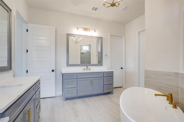 823 Wind River Pass, Azle, TX 76020 - full bath featuring two vanities, a chandelier, a freestanding tub, and a shower