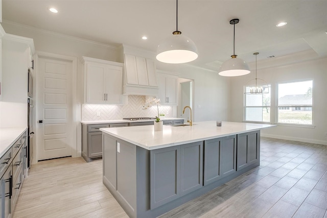 823 Wind River Pass, Azle, TX 76020 - kitchen featuring gray cabinets, a sink, tasteful backsplash, an island with sink, and light wood-type flooring