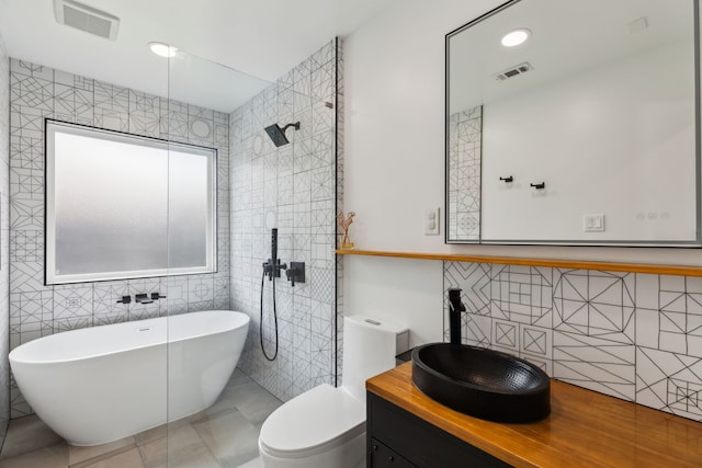826 Ashley Pl, Mesquite, TX 75181 - bathroom featuring tile walls, a freestanding bath, vanity, toilet, and a tile shower