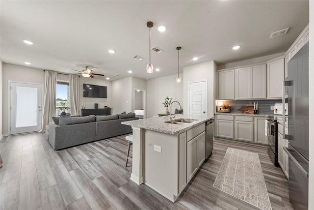 1512 Elise Ave, Waco, TX 76706 - kitchen with a sink, stainless steel appliances, wood finished floors, tasteful backsplash, and recessed lighting