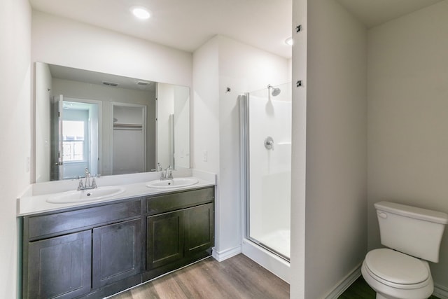 7717 Vineyard Dr, Abilene, TX 79606 - bathroom featuring a shower stall, wood finished floors, double vanity, and toilet
