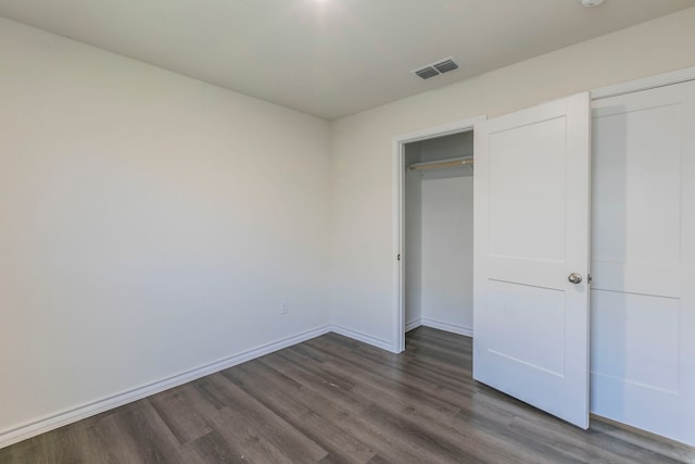 7717 Vineyard Dr, Abilene, TX 79606 - unfurnished bedroom featuring dark wood-style floors, baseboards, and a closet