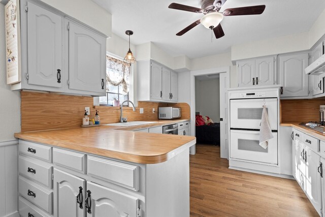 1610 Alpine Pass, Lewisville, TX 75077 - kitchen featuring appliances with stainless steel finishes, ceiling fan, a peninsula, light countertops, and light wood-style flooring