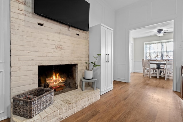 1610 Alpine Pass, Lewisville, TX 75077 - living area with a fireplace, wood finished floors, a decorative wall, and a ceiling fan