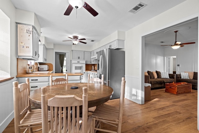 1610 Alpine Pass, Lewisville, TX 75077 - dining space featuring a ceiling fan, light wood finished floors, and a decorative wall