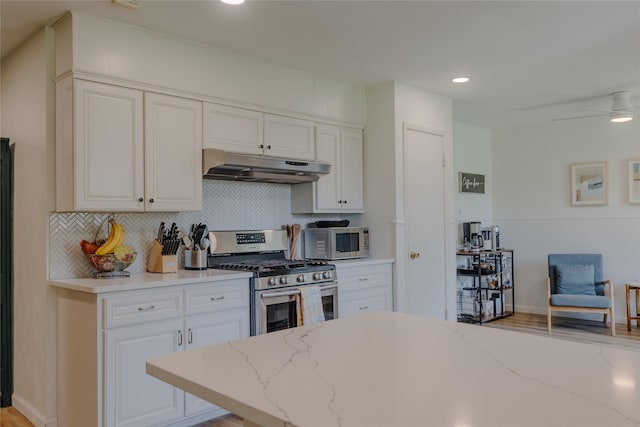 2712 Larkin Ave, Fort Worth, TX 76133 - kitchen featuring under cabinet range hood, stainless steel gas range, white microwave, backsplash, and recessed lighting