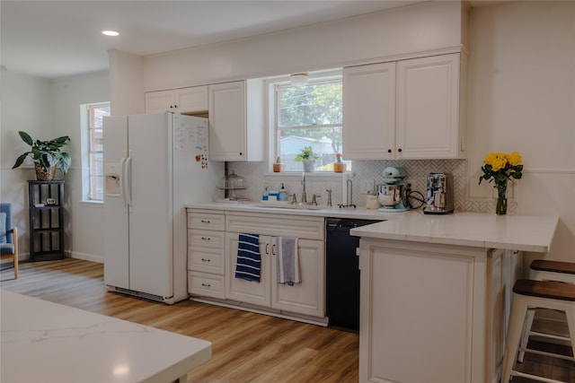 2712 Larkin Ave, Fort Worth, TX 76133 - kitchen featuring white fridge with ice dispenser, black dishwasher, a sink, light wood-style flooring, and decorative backsplash
