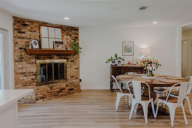 2712 Larkin Ave, Fort Worth, TX 76133 - dining room with light wood-style floors, a brick fireplace, baseboards, and recessed lighting