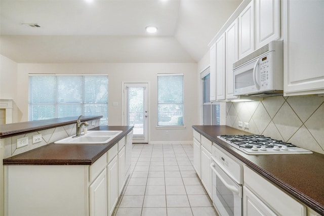 8393 Davis Dr, Frisco, TX 75036 - kitchen featuring white appliances, dark countertops, a sink, tasteful backsplash, and vaulted ceiling