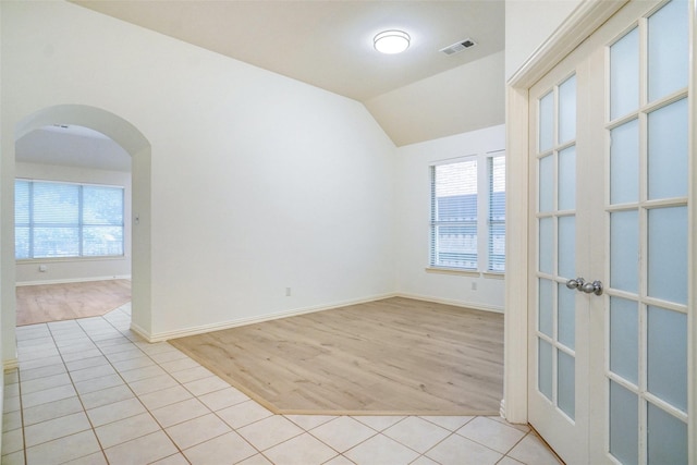 8393 Davis Dr, Frisco, TX 75036 - unfurnished room featuring arched walkways, french doors, light wood-style flooring, vaulted ceiling, and baseboards