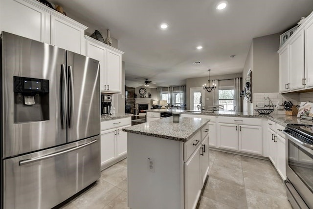 1713 Cattleman St, Van Alstyne, TX 75495 - kitchen with stainless steel appliances, a peninsula, ceiling fan, decorative backsplash, and recessed lighting