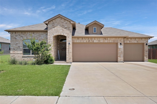 1099 Admiral Dr, Azle, TX 76020 - french country inspired facade featuring an attached garage, concrete driveway, brick siding, and roof with shingles