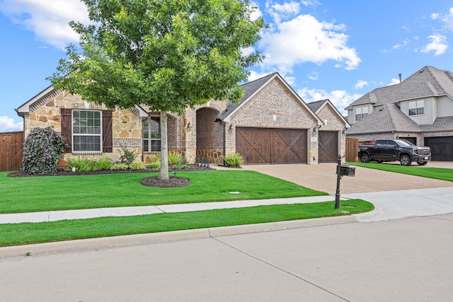 1412 Siena Ln, Rockwall, TX 75032 - view of front of property featuring an attached garage, stone siding, driveway, and a front lawn