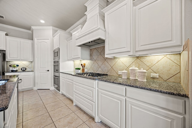 1412 Siena Ln, Rockwall, TX 75032 - kitchen featuring custom range hood, light tile patterned flooring, white cabinetry, crown molding, and dark stone counters
