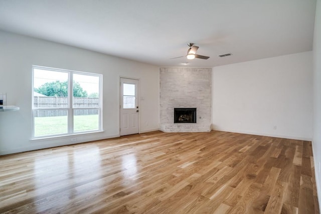 1467 Norfolk Ct, Allen, TX 75002 - unfurnished living room with a ceiling fan, light wood-style flooring, a large fireplace, and baseboards