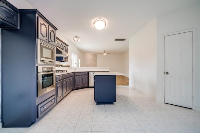 1467 Norfolk Ct, Allen, TX 75002 - kitchen with appliances with stainless steel finishes, a peninsula, a sink, light countertops, and a ceiling fan