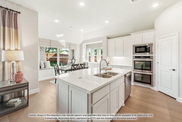 2503 Jennifer Ln, Mansfield, TX 76063 - kitchen featuring a sink, stainless steel appliances, light wood finished floors, white cabinets, and light countertops