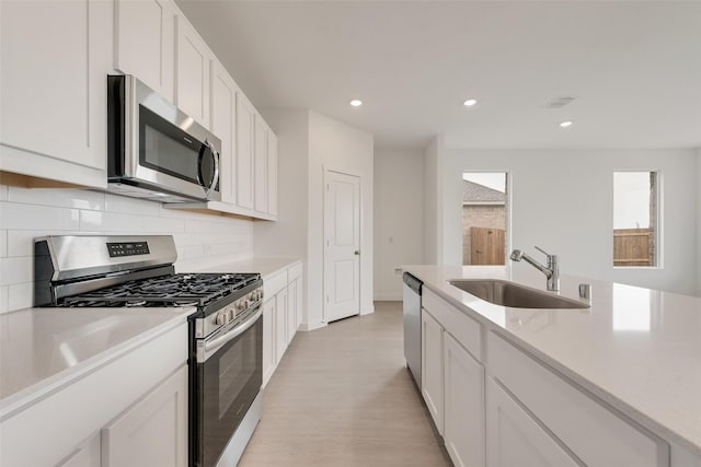 1802 Golden Sq, Cedar Hill, TX 75116 - kitchen featuring stainless steel appliances, a sink, tasteful backsplash, light countertops, and light wood-style floors