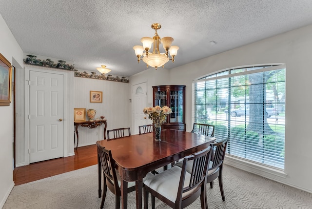 227 Meadowlark Ln, Duncanville, TX 75137 - carpeted dining space with a chandelier, a textured ceiling, and baseboards