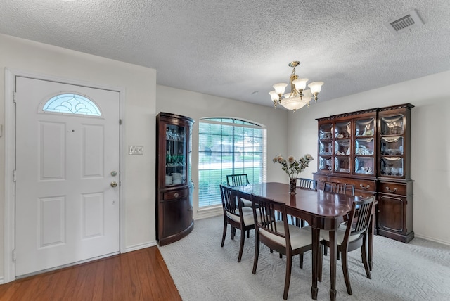 227 Meadowlark Ln, Duncanville, TX 75137 - dining space with a chandelier, light wood-style flooring, baseboards, and a textured ceiling