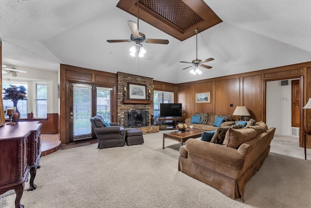 227 Meadowlark Ln, Duncanville, TX 75137 - living room with vaulted ceiling, light carpet, wooden walls, ceiling fan, and a textured ceiling