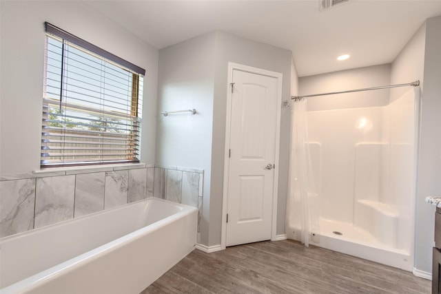 107 Oliver Wendell Ct, Mount Vernon, TX 75457 - full bath featuring a garden tub, wood finished floors, a stall shower, and baseboards