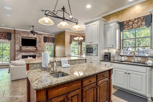 1010 Toledano Cir, Shreveport, LA 71106 - kitchen with an island with sink, a sink, stainless steel microwave, ceiling fan, and recessed lighting