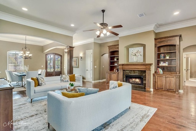 1010 Toledano Cir, Shreveport, LA 71106 - living room with arched walkways, light wood finished floors, a fireplace, ornamental molding, and recessed lighting