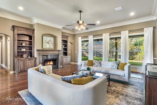 1010 Toledano Cir, Shreveport, LA 71106 - living room featuring arched walkways, a premium fireplace, a ceiling fan, crown molding, and dark wood-type flooring