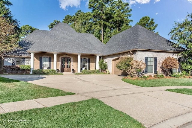 1010 Toledano Cir, Shreveport, LA 71106 - view of front of home featuring driveway, french doors, a front lawn, and a garage