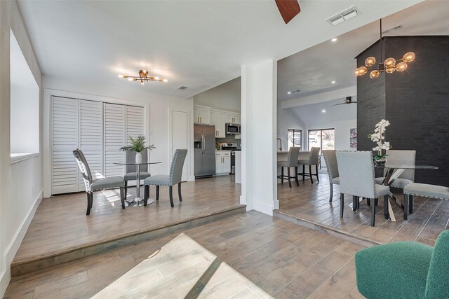 5607 Emrose Cir, Dallas, TX 75227 - dining area with ceiling fan, a chandelier, light wood-style floors, baseboards, and lofted ceiling