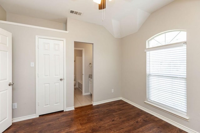 1408 Tartan Dr, Allen, TX 75013 - unfurnished bedroom featuring vaulted ceiling, dark wood-style flooring, connected bathroom, and baseboards
