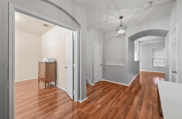 405 Cypress Hill Dr, Mckinney, TX 75071 - hall with arched walkways, wood finished floors, a chandelier, and baseboards