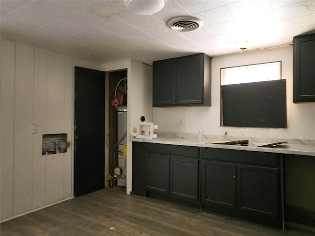 927 London St, Vernon, TX 76384 - kitchen with dark wood-type flooring, water heater, a sink, and light countertops