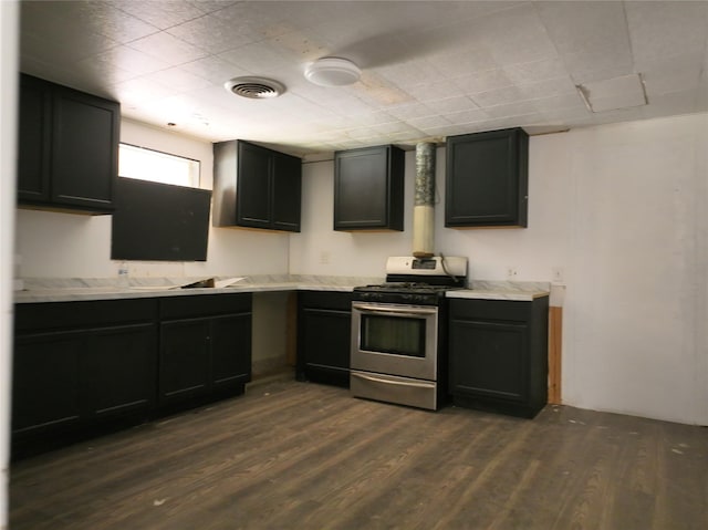 927 London St, Vernon, TX 76384 - kitchen featuring stainless steel gas stove, dark wood-type flooring, light countertops, and dark cabinets