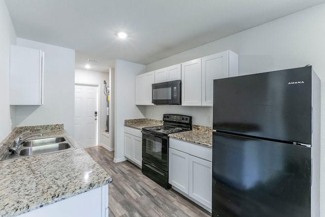 1718 Chestnut St, Abilene, TX 79602 - kitchen with black appliances, a sink, light wood-type flooring, white cabinets, and recessed lighting
