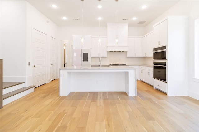 7844 Secluded Ave, Plano, TX 75024 - kitchen featuring white refrigerator, double wall oven, light countertops, light wood finished floors, and white cabinets