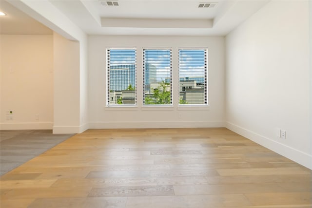 7844 Secluded Ave, Plano, TX 75024 - unfurnished room featuring a tray ceiling, light wood-style flooring, and baseboards