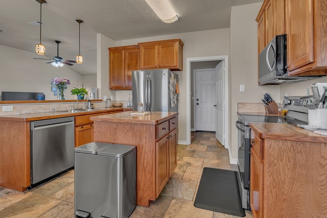 111 Ladonna Ct, Decatur, TX 76234 - kitchen with stainless steel appliances, stone tile flooring, a peninsula, a sink, and ceiling fan