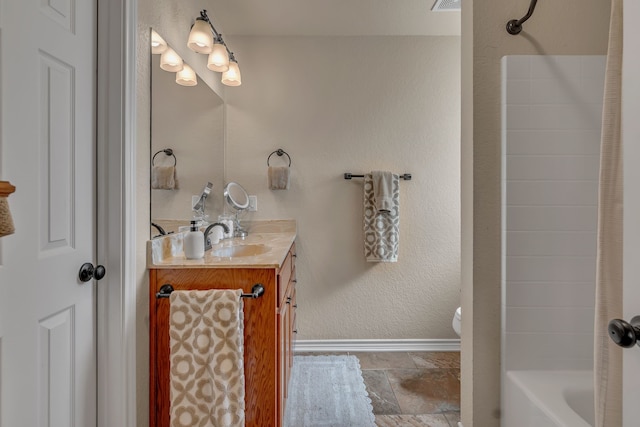 111 Ladonna Ct, Decatur, TX 76234 - bathroom featuring vanity, baseboards, toilet, shower / bath combo, and stone tile flooring