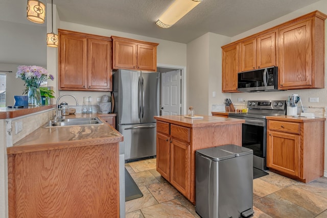 111 Ladonna Ct, Decatur, TX 76234 - kitchen with stainless steel appliances, a sink, stone tile flooring, and a peninsula
