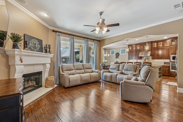 3308 Linkwood, The Colony, TX 75056 - living area with dark wood-style flooring, crown molding, a ceiling fan, arched walkways, and a glass covered fireplace