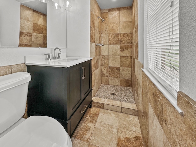 3837 Finley Rd, Irving, TX 75062 - full bath with toilet, stone tile floors, vanity, tile walls, and a tile shower