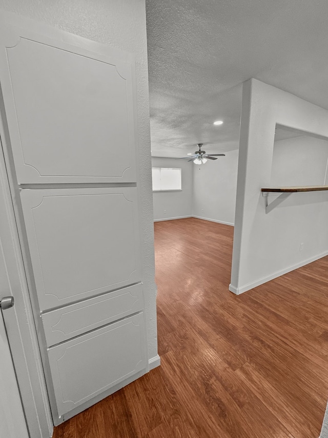 3837 Finley Rd, Irving, TX 75062 - hall featuring wood finished floors, a textured ceiling, and baseboards