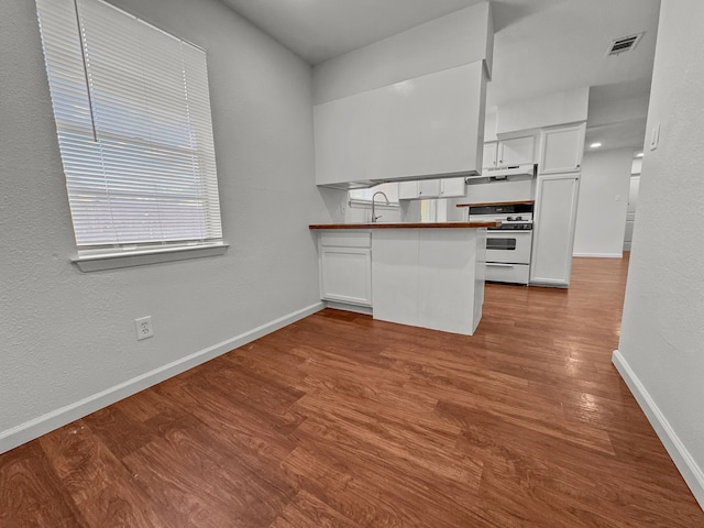 3837 Finley Rd, Irving, TX 75062 - kitchen with white range oven, white cabinetry, and dark wood finished floors