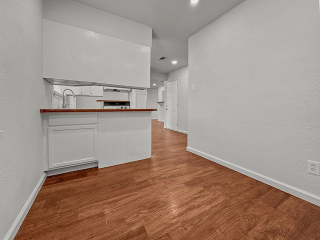 3837 Finley Rd, Irving, TX 75062 - kitchen with wood finished floors, baseboards, recessed lighting, white cabinets, and a textured wall