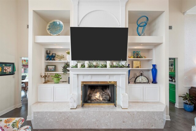 226 Northline Rd, Teague, TX 75860 - living area with a premium fireplace, baseboards, built in features, wood finished floors, and a towering ceiling
