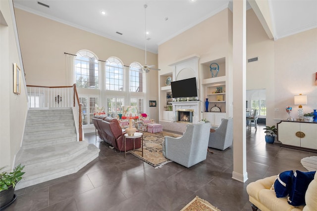 226 Northline Rd, Teague, TX 75860 - living area with a towering ceiling, built in features, a warm lit fireplace, stairway, and ornamental molding